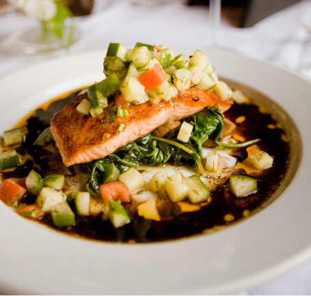 plate of salmon with lots of vegetables served with it