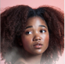 black girl with curly hair facing the left side in a pink background