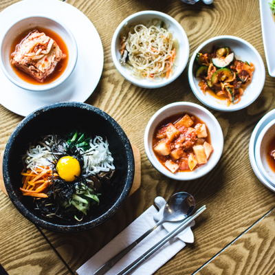 korean food with bibimbap and 4 appetizers including kimchi, bean sprouts, potato and pickled cucumber